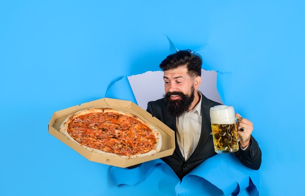 Pizza bezorgconcept lachende man met baard en snor geniet van heerlijke pizza en koud bier