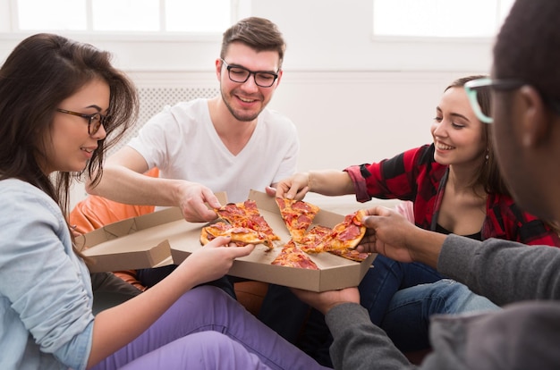 Pizza bezorging. Gelukkige mensen die lunch eten op coworking-kantoor tijdens pauze, bijsnijden, close-up