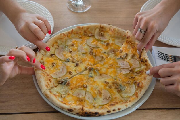 Pizza bismarck en wijn beker op een houten tafel Traditionele ham en brie kaas pizza