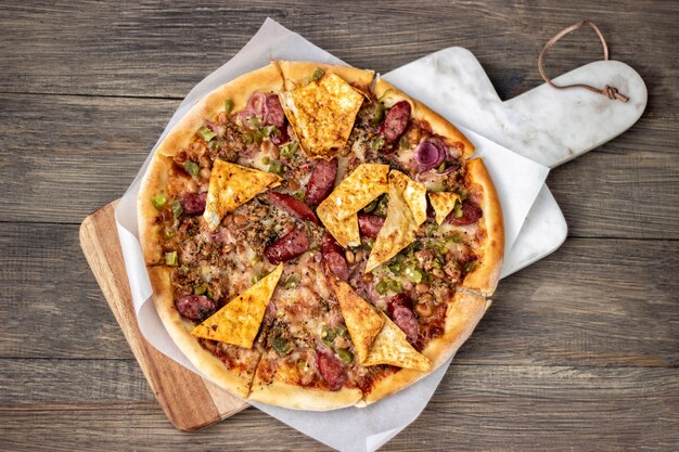 Pizza on a board on a wooden table.