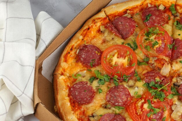 Pizza in a box on the table Hot pizza with vegetables Pizza in a restaurant