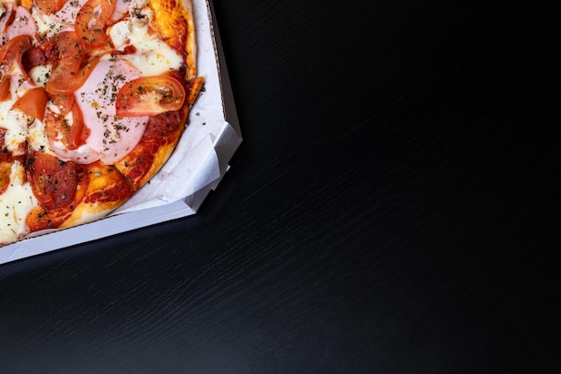 Pizza in a box on a wooden table