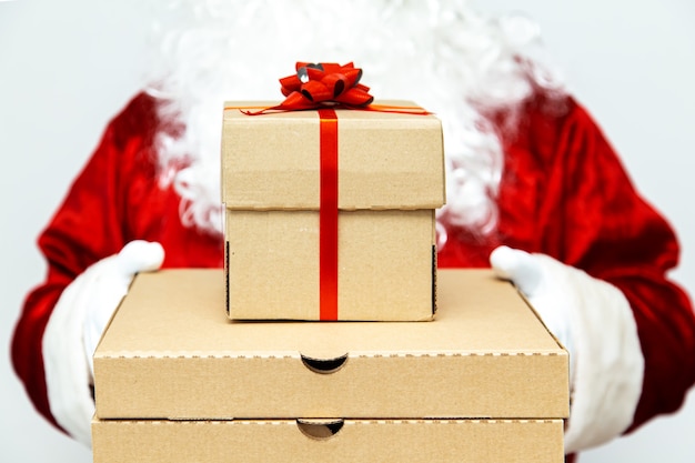 Pizza boxes and a gift in the hands of santa claus. christmas\
fast food delivery. new year\'s eve promotion.