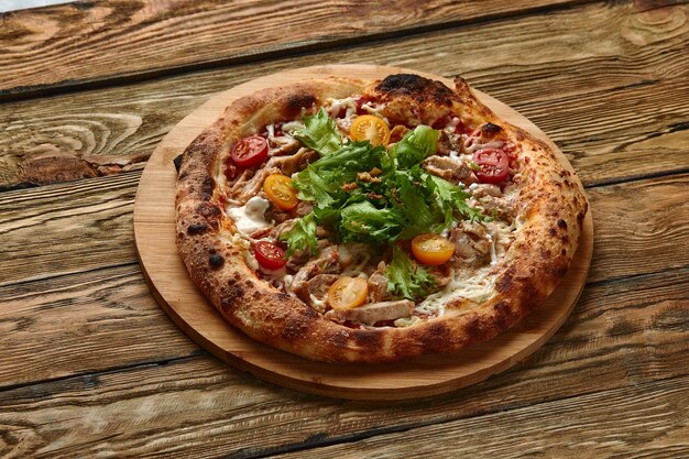 Pizza Caesar Pizza met kip, tomaat, kaas en sla op een houten bord Bovenaanzicht Vrije ruimte voor uw tekst Eten bezorgen
