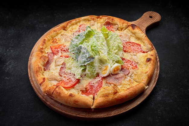 Pizza Caesar on a round wooden board