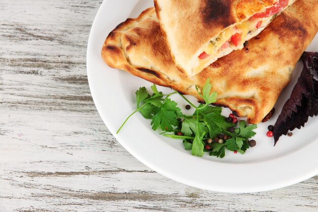 나무 테이블에 접시에 피자 calzones