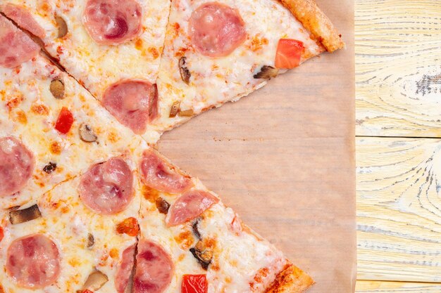 Pizza Capriciosa zonder een stuk op een bakpapier drager.