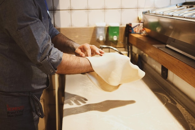 Pizza chef put sauce on base in a commercial kitchen