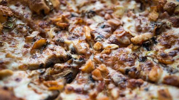 Pizza close-up waarop vlees kaas groenten kruiderijen en sauzen Achtergrond met pizza