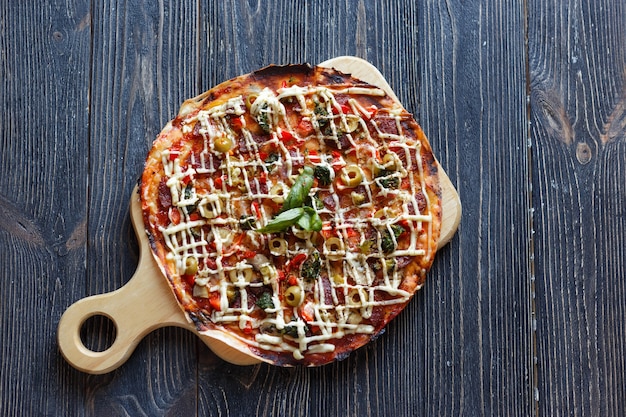 Pizza on dark wooden table. Top view.