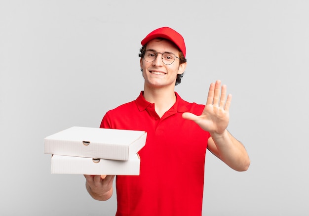 Pizza consegna ragazzo che sorride allegramente e allegramente, agitando la mano, dandoti il benvenuto e salutandoti, o salutandoti