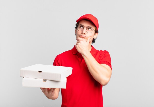 Pizza deliver boy thinking, feeling doubtful and confused, with different options, wondering which decision to make