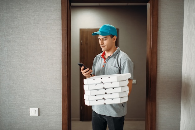 Pizza delivery boy in t-shirt and cap calls to customer