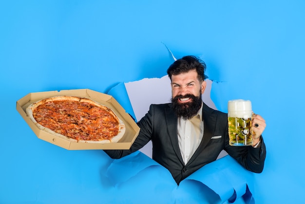 Pizza consegna concetto uomo barbuto con gustosa pizza e birra guardando attraverso il buco della carta pizza time