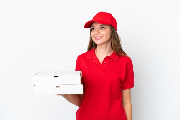 Pizza delivery Lithuanian woman isolated on white background looking to the side and smiling