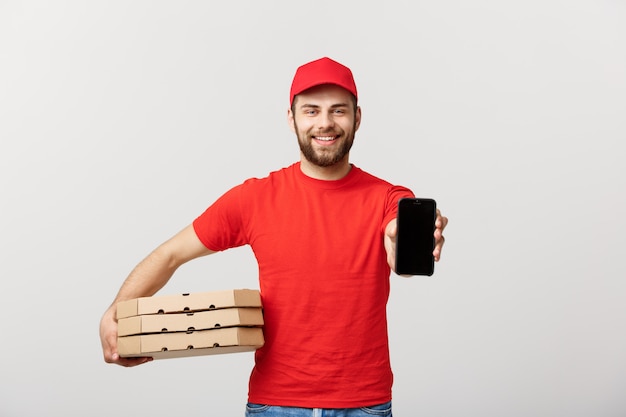 Pizza delivery man holding a mobile and pizza boxes over white