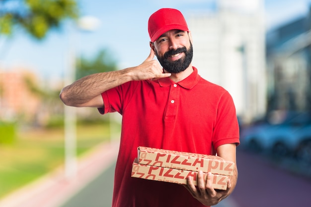 Pizza delivery man maakt telefoon gebaar op ongebruikelijke achtergrond