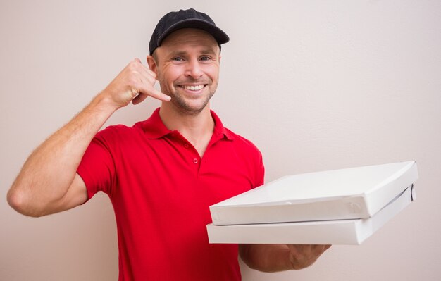 Человек доставки пиццы, делая жестом телефонного звонка