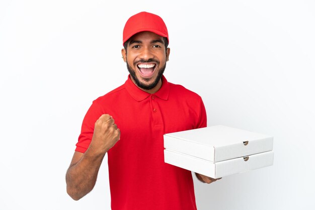 Foto fattorino della pizza che preleva scatole per pizza isolate su sfondo bianco celebrando una vittoria nella posizione del vincitore