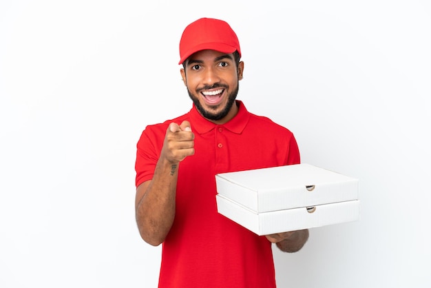 白い背景に分離されたピザの箱を拾うピザ配達人は驚いて正面を指しています