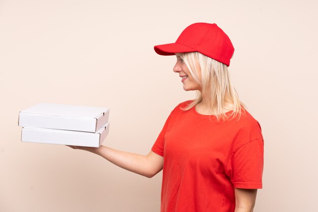 Pizza delivery Russian woman holding a pizza over isolated wall with happy expression