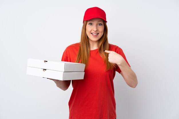 Pizza delivery woman holding a pizza over isolated pink wall with surprise facial expression