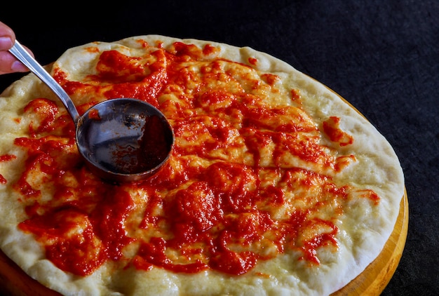 Pizza dough covered with tomato sauce