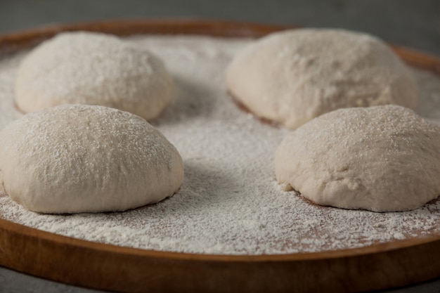 Pizza dough and flour on rolling board