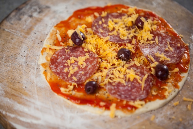 Pasta per pizza con salsa di pomodoro e formaggio grattugiato