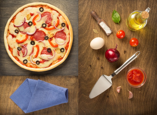 Pizza and food ingredients at wooden table, top view