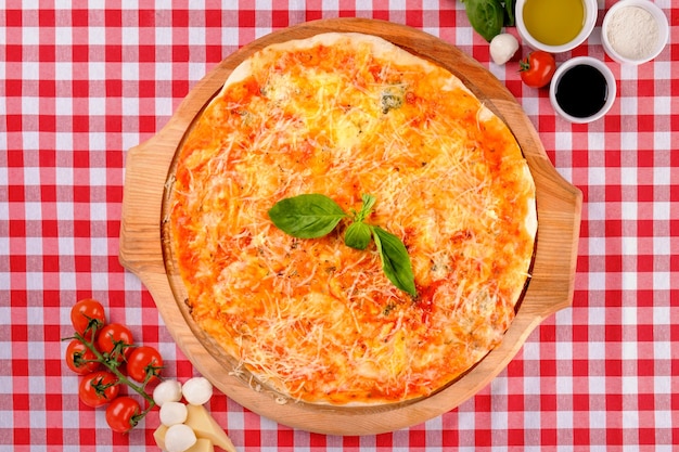 Foto pizza quattro formaggi con mozzarella, gongorzola, parmigiano, ricotta su una tavola di legno