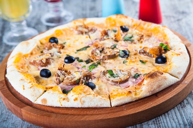 pizza gevuld met tomaten en kaas op een houten tafel