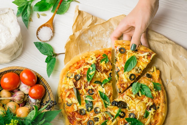 Pizza and hand close up over white 