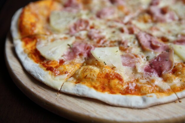 Pizza hawaiian , pizza with pineapple and ham with cheese and tomatoes sauce on wood background , italian food