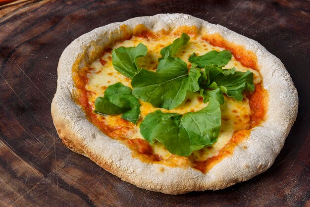 Pizza Homemade cheese pizza with arugula over wood