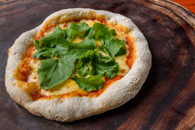 Pizza Homemade cheese pizza with arugula over wood