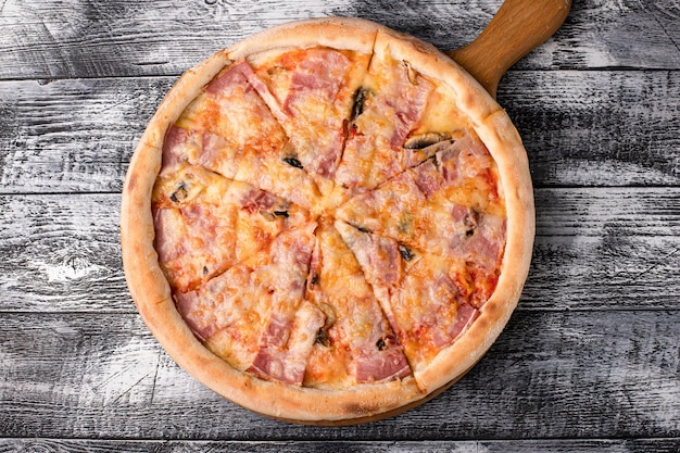 Пицца горячая пицца на белом деревянном фоне сбоку и вид сверху