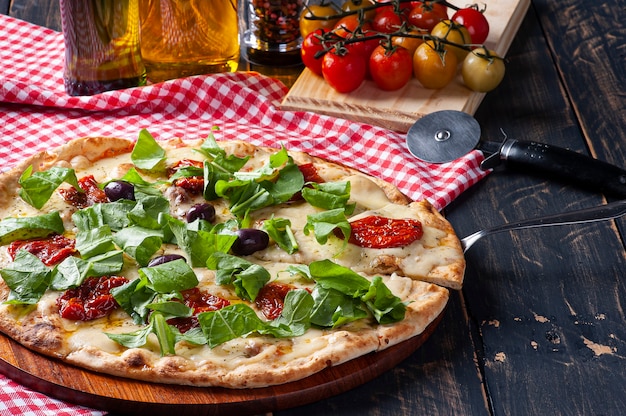 Pizza in braziliaanse stijl met mozzarella, zongedroogde tomaten en rucola.