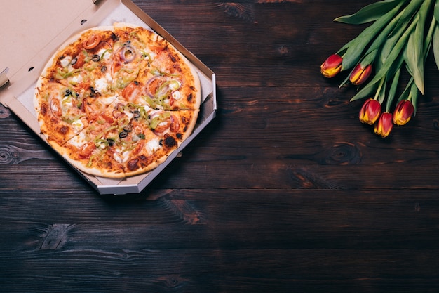 Pizza in een doos en een boeket tulpen