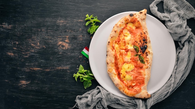 Pizza Italiaans traditioneel gerecht Op een houten achtergrond Bovenaanzicht Gratis kopieerruimte