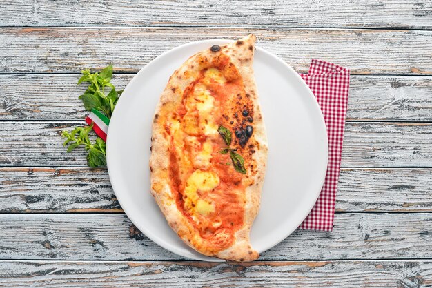 Pizza Italian traditional dish On a wooden background Top view Free copy space