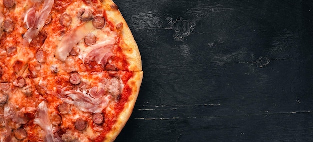 Pizza Lardon Bacon cherrytomaatjes worst salami Op een houten ondergrond Bovenaanzicht