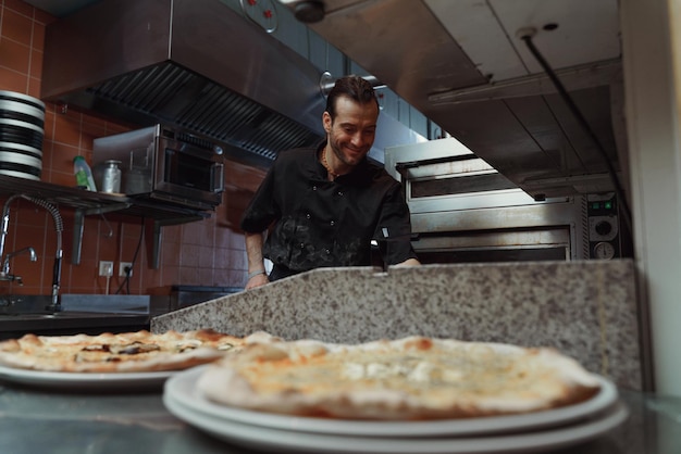 Pizza making process male chef making authentic pizza in the pizzeria kitchen