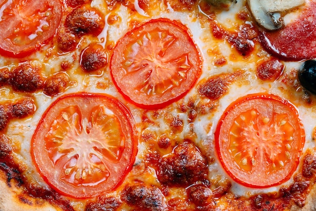 Pizza Margarita close-up met kaas en tomaten.