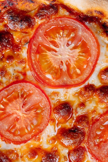 Pizza Margarita close-up met kaas en tomaten.