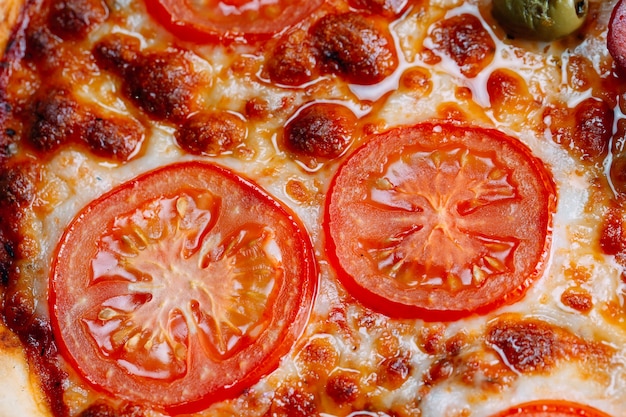 Pizza Margarita close up with cheese and tomatoes.