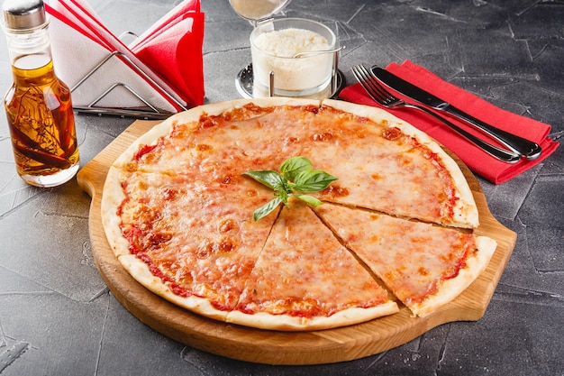 Pizza Margarita op een houten bord op donkere achtergrond