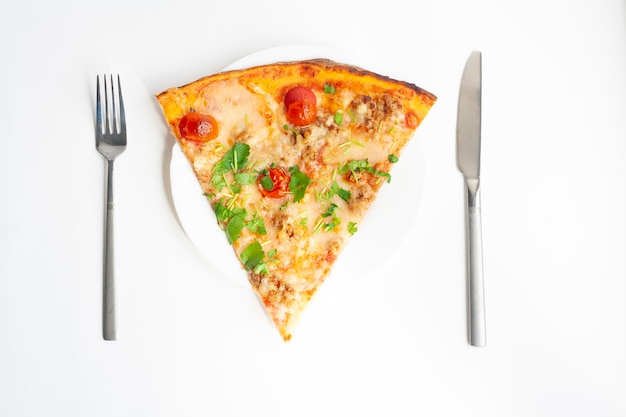 Pizza Margarita on a plate, fork and knife, flat lay