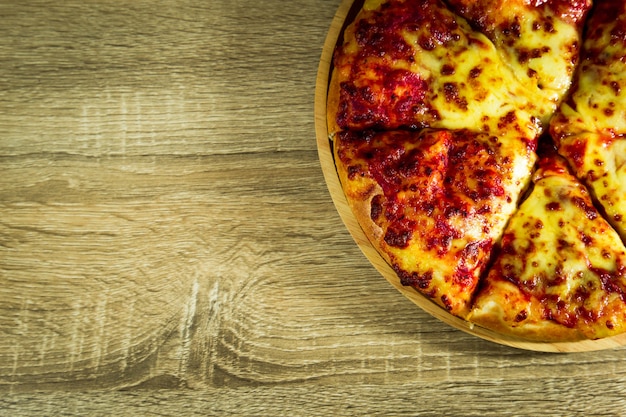 Pizza Margarita with mozzarella cheese on a wooden table