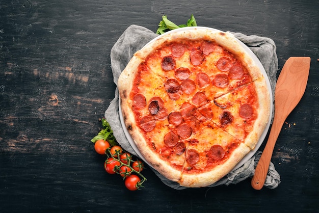 Pizza Margarita with sausages and tomato sauce On a wooden background Top view Free space for your text